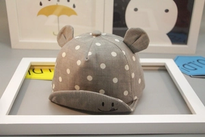 Detail of gray baby baseball cap with white polka dots, soft brim, and cute 3D ears