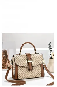 Close-up of retro two-tone handbag featuring textured cross-pattern and gold metal lock