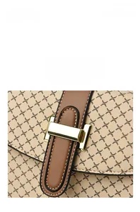 Close-up of golden metal buckle and geometric pattern on beige crossbody bag