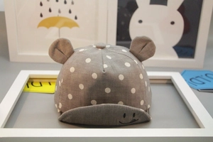 Close-up of grey baby sun hat with white polka dots, 3D ears and smiley face print