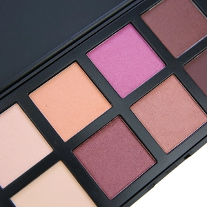 Macro shot of an 8-color matte and shimmer eyeshadow palette with earthy and nude tones