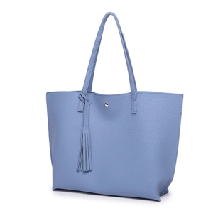 Detail of light blue lychee texture leather tote bag with stylish long tassel and gold buckle