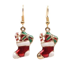 Detailed close-up of Christmas stocking earrings with red and green enamel and gold hooks