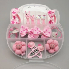 Close-up of pink flower hair clips and bows organized in a clear compartment box