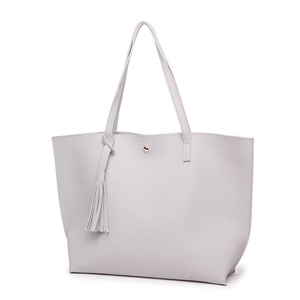 Close-up of light grey lychee texture leather tote bag with tassel and gold metal clasp