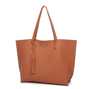 Macro detail of brown litchi pattern leather tote bag with tassel and magnetic closure