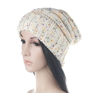 Dettaglio del berretto in maglia beige con punti colorati e risvolto a costine larghe