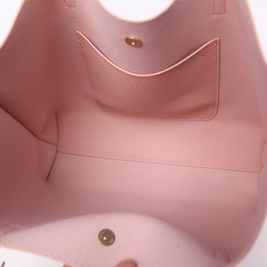 Pink tote bag interior detail showing litchi texture pocket and golden magnetic snap closure