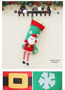 Detail of Christmas stocking featuring Santa Claus doll with striped legs and snowflake embroidery