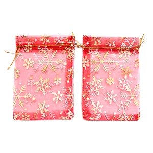 Red organza drawstring gift bags with gold snowflake pattern for Christmas decor