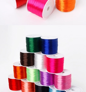 Close-up of 0.7mm elastic crystal beading threads in various colors on white spools