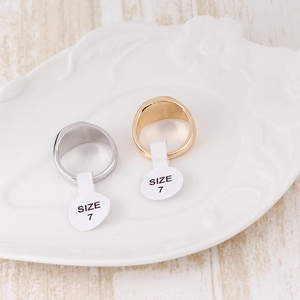 Detail of 18K gold and silver plated men's rings on a vintage embossed white ceramic plate