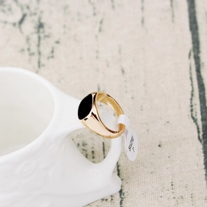 Detailed macro view of 18K gold-plated ring with black enamel top and size 7 label