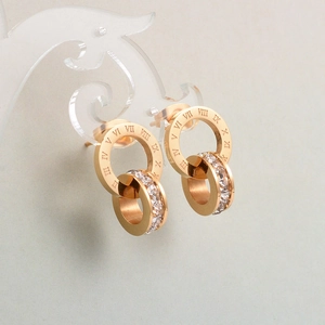 Close-up of rose gold double ring earrings with Roman numerals and sparkling crystals
