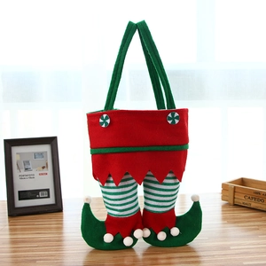 Christmas elf leg felt candy bag in red and green festive colors on a wooden table