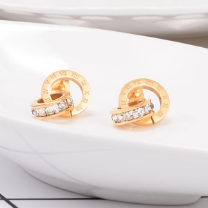 Macro shot of rose gold double ring earrings with Roman numerals and pave zircon stones