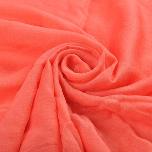 Coral pink soft cotton linen scarf styled in a spiral shape with premium texture