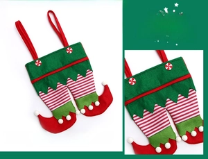 Detail of Christmas elf legs candy bag with red and green stripes and pom pom decoration