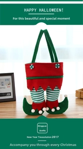Detail of Christmas elf leg candy bag made of red and green felt with festive pom poms