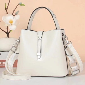 Detail van de crème bucket bag met afneembare leren en jacquard geweven riemen
