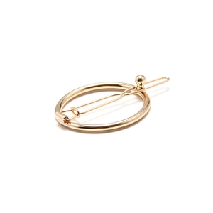 Minimalist golden round alloy hair clip with a smooth metallic finish on white background