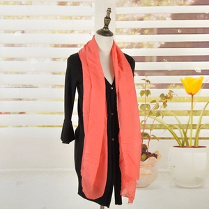 Orange oversized cotton linen scarf for women elegantly draped on a black mannequin