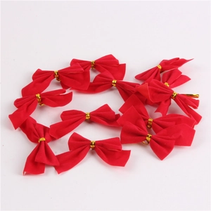 Close-up of small red flocked Christmas bows with gold twist ties for tree decoration