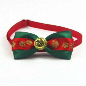 Dettaglio del papillon festivo rosso e verde per animali con campanellino dorato e osso