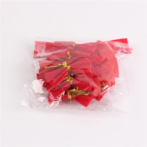 Bulk red flocked Christmas bows in transparent plastic packaging with golden twist ties