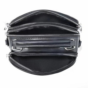 Top view of black multi-compartment shoulder bag showing three separate zipper sections