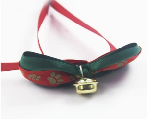 Dettaglio del farfallino per animali con stampe di zampe dorate e campanello metallico