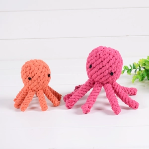 Detail of octopus-shaped cotton rope dog chew toys in bright orange and rose red colors