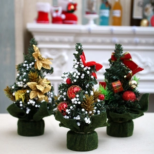 Three mini Christmas trees with bows and golden flowers on a festive fireplace mantel