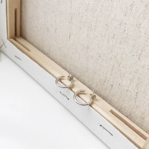 Macro shot of minimalist S925 sterling silver C-shape hoop earrings on a wooden frame