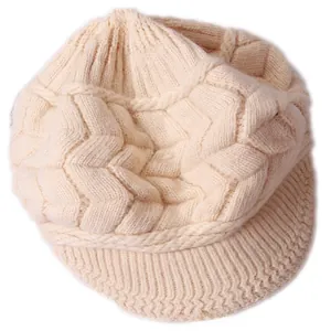 Dettaglio macro del berretto in maglia a trecce beige con visiera e trama calda