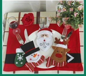 Close-up of Santa and Snowman felt cutlery holders on a red festive table mat