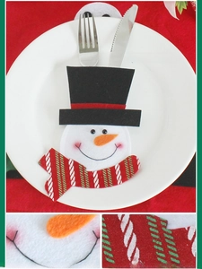 Detail of cartoon snowman cutlery holder with red and green scarf for Christmas tables