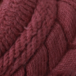 Dettaglio del berretto in maglia rosso scuro in pelo di coniglio con motivo a trecce soffici