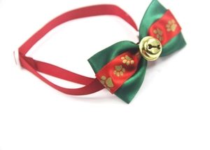 Dettaglio papillon rosso e verde per animali con campanello dorato e motivo a osso