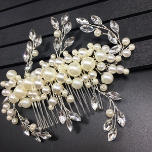 Macro detail of handmade bridal hair comb with pearls and silver wire leaf crystals