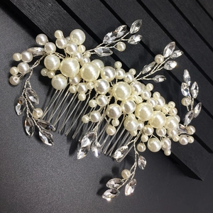 Detailed close-up of bridal hair comb with pearls and rhinestones on black background
