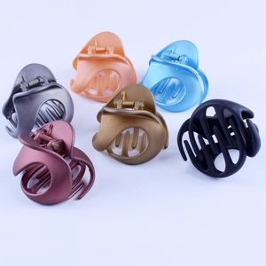 Top view of 12cm matte bow-shaped hair claws in six various colors on white background