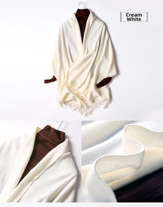 Detail of cream white knitted shawl with fringe and soft wool texture for women