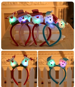 Detail view of glowing Christmas headbands with LED lights and sequin cartoon characters