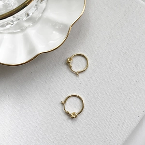 Detail showing S925 hallmark on gold-plated sterling silver knotted hoop earrings