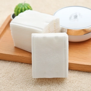 Pack of square cotton pads for makeup removal and cleansing on wooden tray