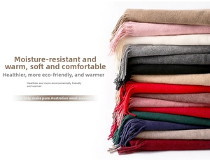 Detail showing various colors of thick wool scarves with fringe on a white background