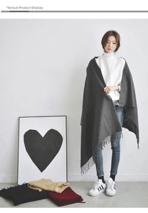 Detail of dark grey fringe scarf showing wool-like texture and draped tassel edges