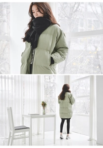 Front and back view of long loose light green down jacket with black scarf