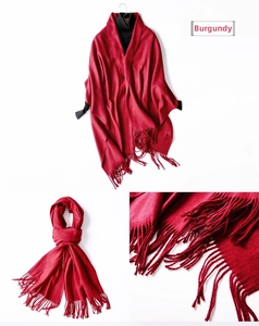 Detailed view of jujube red knit scarf featuring thick wool texture and elegant long tassels